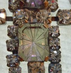 a brooch with many different colored stones on it's back and center piece