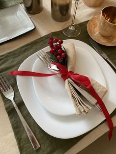 a white plate topped with a fork and knife next to a napkin on top of a table