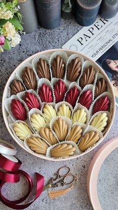 a bowl filled with chocolates next to some scissors and other crafting supplies on top of a table