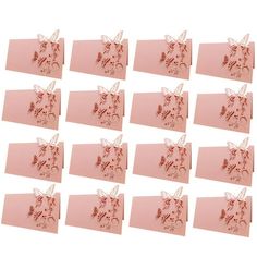 twelve pink envelopes with red flowers and butterflies on them, all lined up in rows