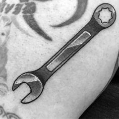 a man with a wrench tattoo on his arm