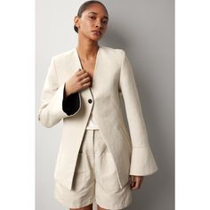 Beige virgin wool and hemp blend (50% Virgin Wool, 50% Hemp). Jacket. Long sleeves. Front button closure. 30" from shoulder to hemline. Imported. Elegant Linen Blazer With Button Cuffs, Chic Beige Blazer With Button Cuffs, Fitted Linen Blazer With Button Cuffs, Tailored Linen Blazer With Button Cuffs, Chic Linen Blazer For Tailoring, Chic Linen Outerwear With Buttons, Chic Tailored Linen Outerwear, Linen Spring Outerwear With Button Cuffs, Spring Linen Outerwear With Button Cuffs