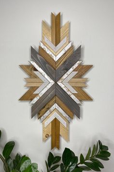 a wooden snowflake sitting on top of a table next to a potted plant