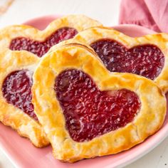 two heart shaped pastries on a pink plate