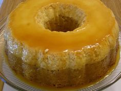 a cake sitting on top of a glass plate covered in yellow icing and caramel