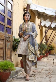 The set consists of straight cut handwork printed kurta with gota detailing, 3/4th sleeves, round neck, knee length teamed with printed trouser and a dupatta with border. Suit Fabric-Georgette Dupatta Fabric-Organza Kurta length - 40 in Pants length - 38 in Model is wearing size small. She is 5.8” tall. Washing Care-Dry Clean Organza Kurta, Georgette Dupatta, Grey Suit, Gray Suit, Suit Fabric, Pants Length, Suit Set, Raw Silk, Straight Cut