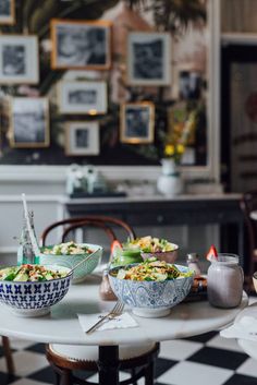 two bowls of food on a table in a room with black and white checkered flooring