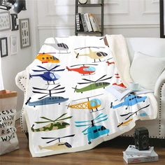 a white couch sitting next to a window covered in a blanket with airplanes on it