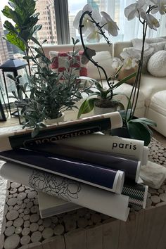 three books are stacked on top of each other in front of a window with flowers