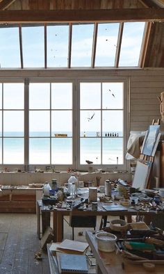 an artist's studio with large windows overlooking the ocean