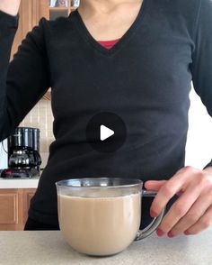 a woman holding a cup with liquid in it