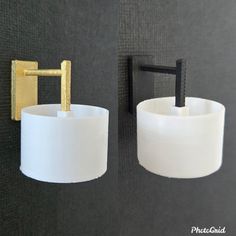 two toilet paper holders on the wall next to each other