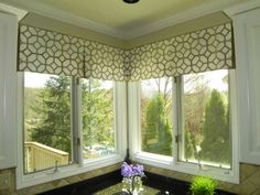 a kitchen with two windows and a sink in front of the window, next to a potted plant