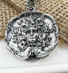 "Hand made Design by Sal Knight The Medusa in sterling silver light antique finish with ruby eyes 30 millimeters wide, 1 1/4\" inches Double linked sterling silver chain" Spiritual Jewelry With Antique Finish, Silver Hand Forged Medallion Jewelry, Artisan Antique Silver Round Jewelry, Antique Silver Sterling Silver Jewelry, Antique Silver Sterling Silver Jewelry With Antique Finish, Antique Silver Round Pendant Jewelry With Antique Finish, Antique Silver Jewelry With Antique Finish Pendant, Sterling Silver Jewelry With Antique Finish Round Pendant, Sterling Silver Jewelry With Antique Finish In Antique Silver