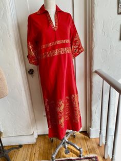 This is a beautiful red cotton blend caftan made in Greece by B.E.T.Y.K. . It features Grecian key and floral gold metallic embroidery, a collared neckline, side hem vents, and cuffed half sleeves. It pulls over the head and has a hook and eye at the throat. It falls to the ankle and is close to a shift silhouette. Size label says 1 but is probably a Medium based on the mannequin size. It measures 36" around the bust, the waist is 35", the hips are 38" the length is 48" and the drop shoulders are 19" across. Excellent vintage condition. Hand or gentle machine wash. Size Medium. Red Ceremonial Kaftan For Festivals, Red Embroidered Long Sleeve Kaftan, Festive Red Kaftan With Gold Embroidery, Red Festival Tunic Kurta, Red Long Cotton Kaftan, Red Tunic Kurta For Festival, Red Embroidered Cotton Kaftan, Long Red Cotton Kaftan, Embroidered Cotton Red Kaftan