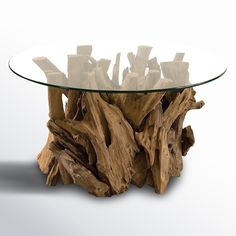 a glass table with driftwood on top sitting on a white surface in front of a white background