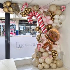 the balloon arch is decorated with gingerbreads, candy canes and christmas decorations