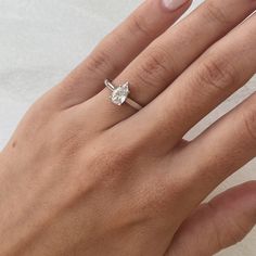 a woman's hand with a diamond ring on it