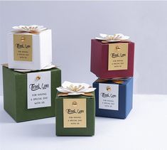 four small boxes with bows and labels on the sides, each containing a gift box