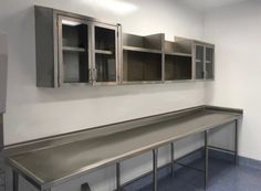 an empty kitchen with stainless steel counter tops and cupboards on the wall behind it