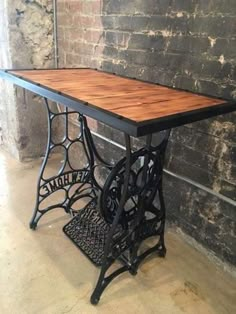 an old fashioned sewing machine table in front of a brick wall