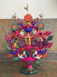 a colorful tree with birds sitting on top of it