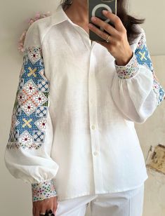 White linen blouse with bright color embroidery. Folk cultural embroidery. Fashion embroidered garment. Natural superb fabric and generous embroidery. Beautiful garment. It is very difficult to convey the real beauty of the embroidery, the glow and the iridescence of the threads in the photo. Delivery usually takes up to 1-2 weeks in total, this includes 3-7 days for production and 3-7 days for shipping to Europe and to the USA. We use FeDex and UPS express shipping. Returns and Exchanges We gla Bohemian Top With Multicolor Embroidery, Traditional Long Sleeve Top With Embroidered Cuffs, Traditional Long Sleeve Embroidered Top With Embroidered Cuffs, Traditional Multicolor Embroidered Top With Embroidered Sleeves, Multicolor Embroidered Folk Top With Embroidered Border, White Embroidered Lantern Sleeve Blouse, Bohemian Blouse With Bishop Sleeves And Floral Embroidery, Bohemian Embroidered Blouse With Bishop Sleeves, Folk Style Blouse With Multicolor Embroidery