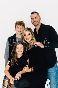 a family posing for a photo in front of a white background