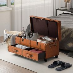 an open suitcase sitting on top of a rug next to shoes and bags in front of a bed