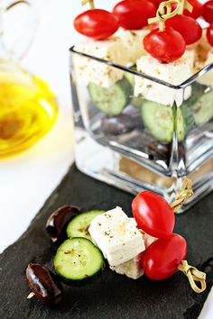 cucumbers, tomatoes, olives and feta cheese on a black slate