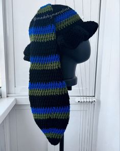 a knitted hat on top of a mannequin's head in front of a white door