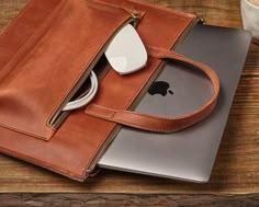 an apple laptop is sitting in a leather case