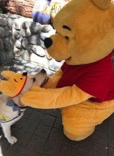 there is a dog standing next to winnie the pooh