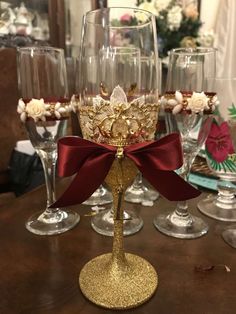 there is a wine glass with a red bow on it and several other glasses in the background