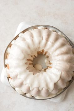 a frosted bundt cake sitting on top of a white counter next to a napkin