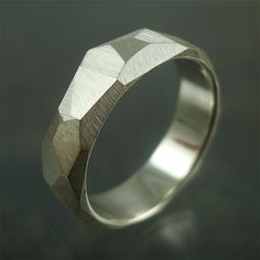 a silver ring with geometric designs on it