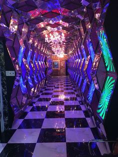 the hallway is decorated in purple and black with lots of mirrors on each side that are lit up by colorful lights