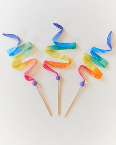 four colorful lollipop sticks with streamers on them