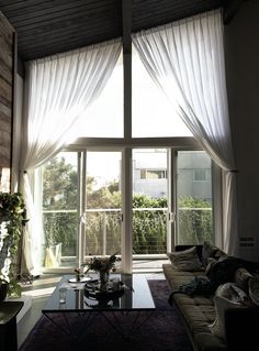 a living room with large windows and curtains