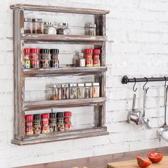 an old wooden spice rack with spices on the wall next to a cutting board and utensils