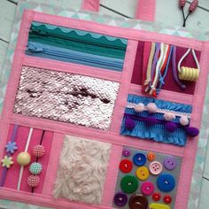 a close up of a pink bag with buttons and other items on the back ground