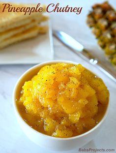 pineapple chutney in a white bowl with crackers on the side