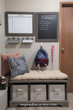 an entryway with storage bins and a chalkboard on the wall above it