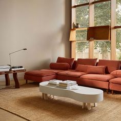 a living room filled with furniture next to a large window covered in lots of windows