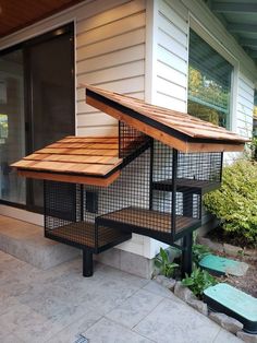 a bird house sitting on top of a wooden platform next to a door and window