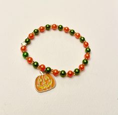 Beaded elastic bracelet with orange and green beads and an enamel charm of a jack-o'-lantern pumpkin. This bracelet will complete your festive look in October or at the Halloween party! 🎃 Preferably wear it with our matching handmade necklace  ----------- 💗All our jewelry is handmade with love. The elastic bracelets are stretchy. Kids normally have a size between 12 - 15 centimeters, and adults 16-20 centimeters. Of course this may vary. To make sure your new bracelet fits, measure your wrist Elastic Bracelets, Jack O'lantern, Jewelry Halloween, Halloween Bracelet, New Bracelet, Halloween Beads, Small Bracelets, Green Beads, Orange And Green