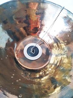 a close up of a metal disk with a clock on it's center piece