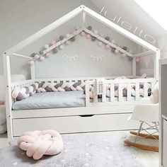 a baby's room with pink and white decor on the walls, bed in the middle