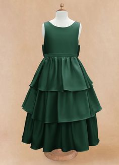 a green dress with tiered ruffles on the bottom, and a mannequin head