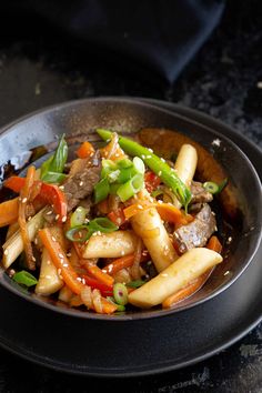 a bowl filled with stir fry vegetables on top of a table